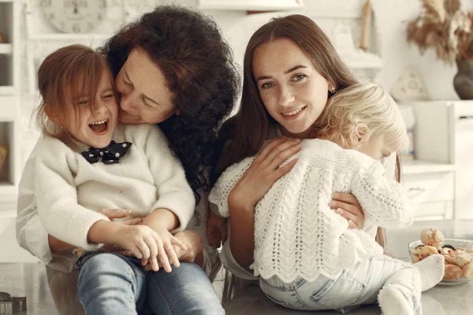 A joyful family gathering in a cozy kitchen with three generations bonded in happiness.
